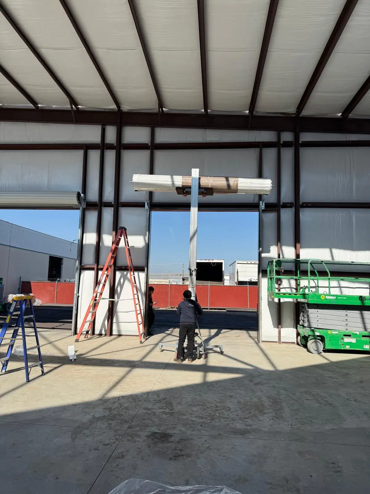 12x14 Janus Roll-Up Door Installation for a Commercial Metal Building — Metal building door installation, guide and bracket mounting, barrel and curtain setup, chain hoist alignment. Product/job: 1 —