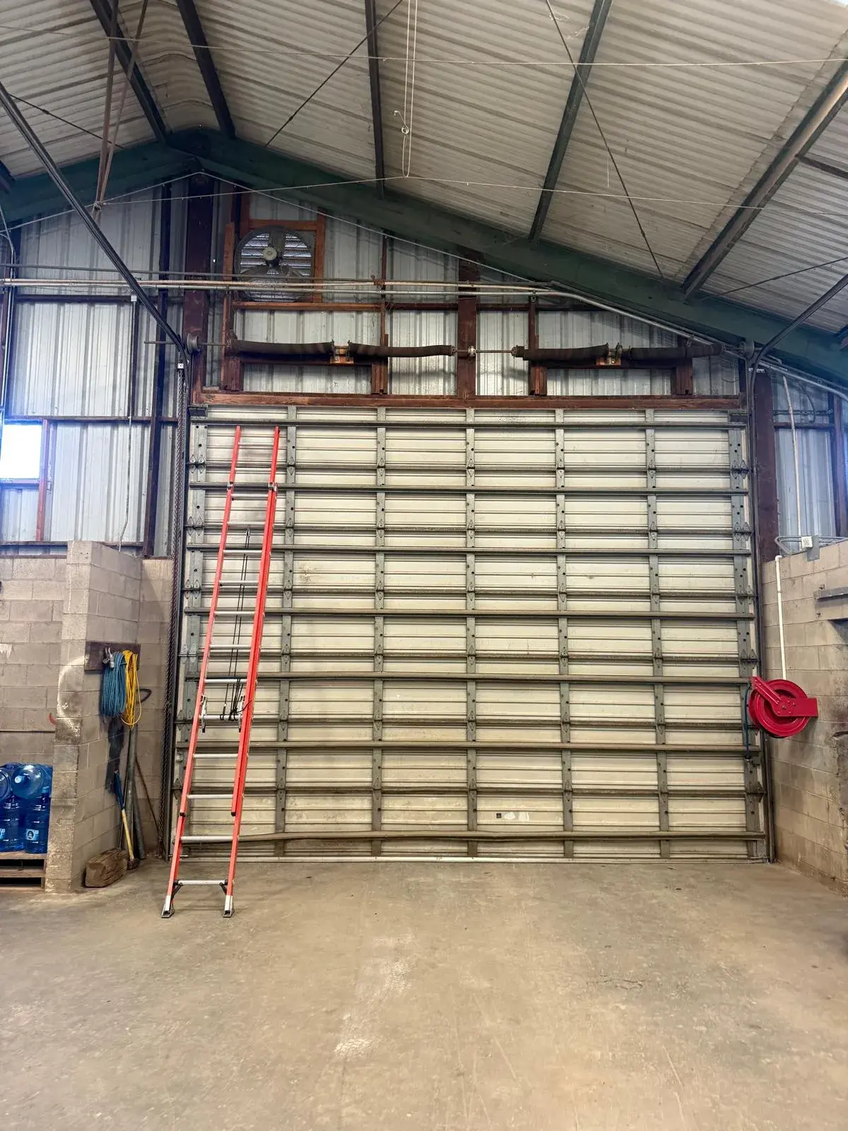 Broken Spring Replacement on a 16x14 Commercial Sectional Door — Commercial torsion spring replacement, cable and drum inspection, balance adjustment, test cycle. Product/job: 16' x 14' comm — aprofes