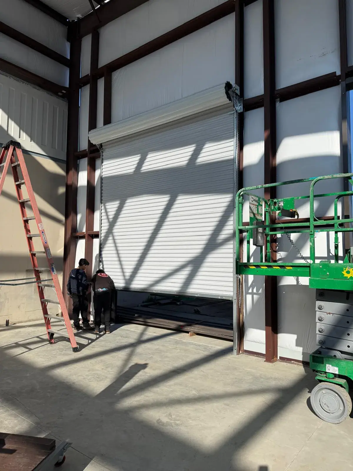 12x14 Janus Roll-Up Door Installation for a Commercial Metal Building — Metal building door installation, guide and bracket mounting, barrel and curtain setup, chain hoist alignment. Product/job: 1 —